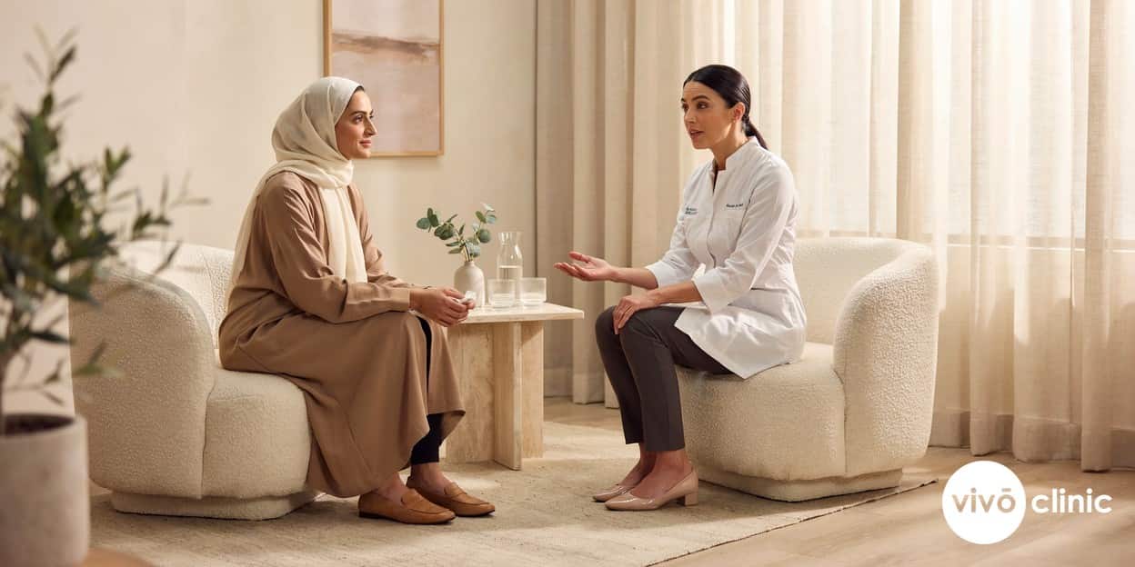 Reassuring Middle Eastern woman in modest dress speaking with a female practitioner during a post-partum HIFU vaginal tightening consultation at VIVO Clinic Dubai