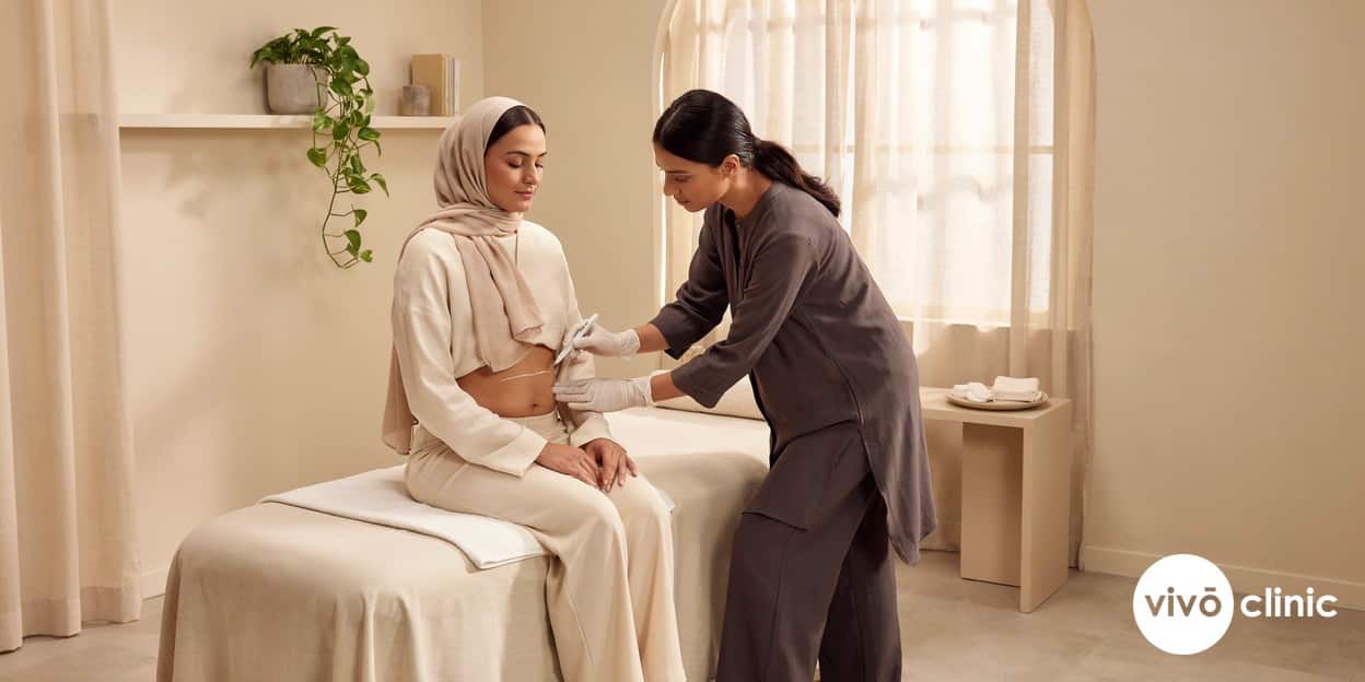 Middle Eastern woman with white cosmetic marking lines drawn on her abdomen during a fat freezing safety consultation at VIVO Clinic Dubai