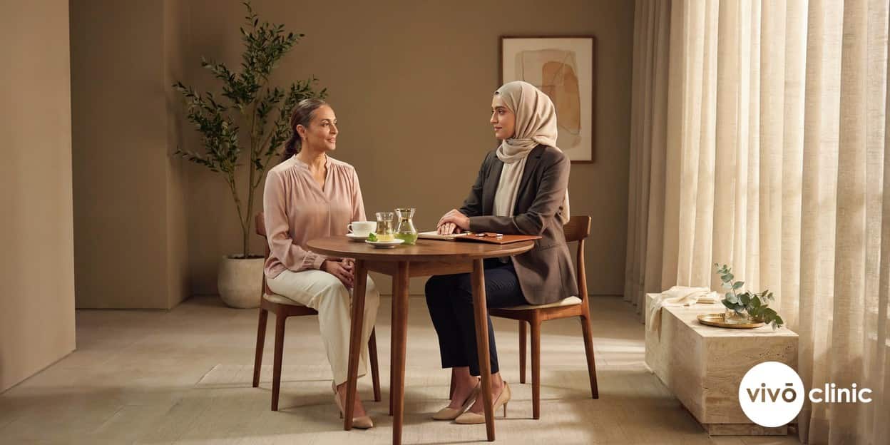 Reassured Middle Eastern woman in her fifties speaking with a female practitioner during a confidential HIFU vaginal tightening consultation at VIVO Clinic Dubai