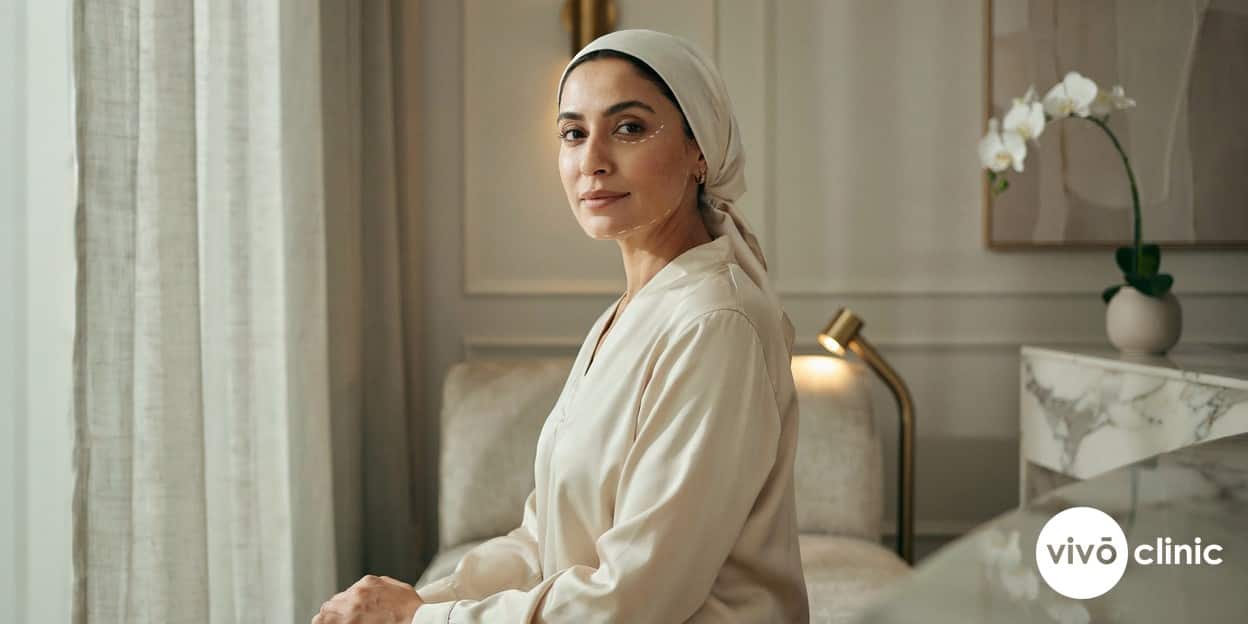 Middle Eastern woman with white cosmetic marking lines along her jawline and around her eyes during a non-surgical skin tightening consultation at VIVO Clinic Dubai