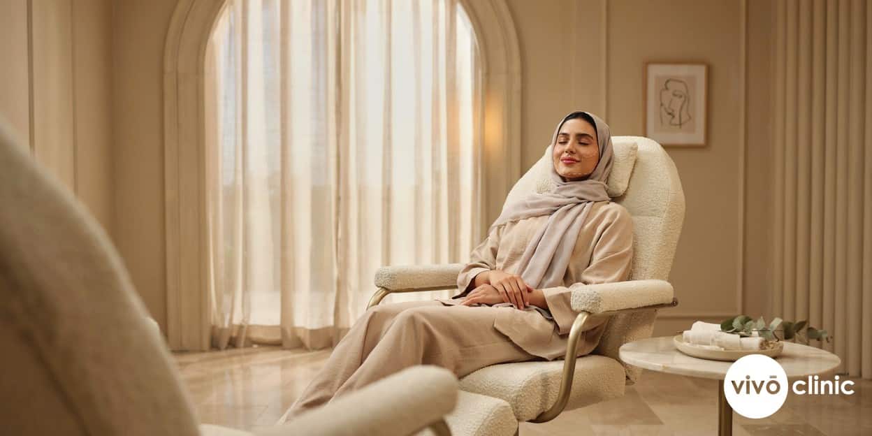 Calm Middle Eastern woman in modest dress relaxing in a treatment chair with white cosmetic mapping lines along her jawline before a HIFU facelift at VIVO Clinic Dubai