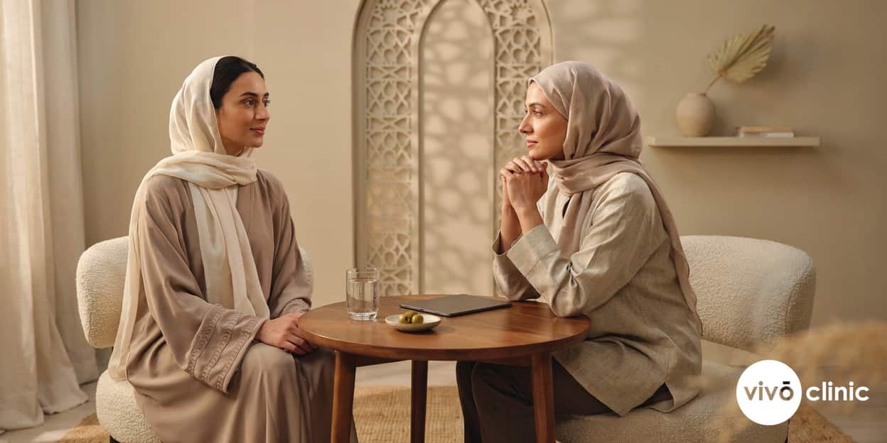 Middle Eastern woman in modest dress speaking with a female practitioner during a private, discreet HIFU vaginal tightening safety consultation at VIVO Clinic Dubai