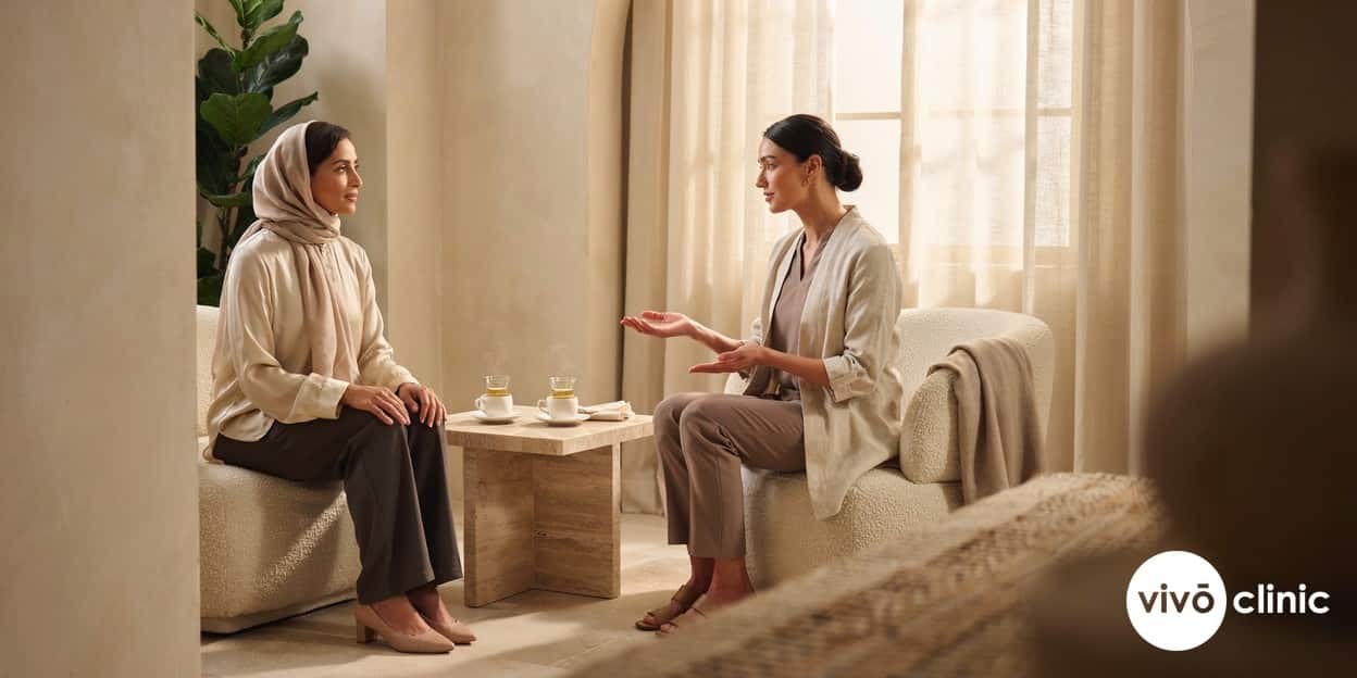 Middle Eastern woman in modest clothing speaking calmly with a female practitioner during a private intimate wellness consultation at VIVO Clinic Dubai