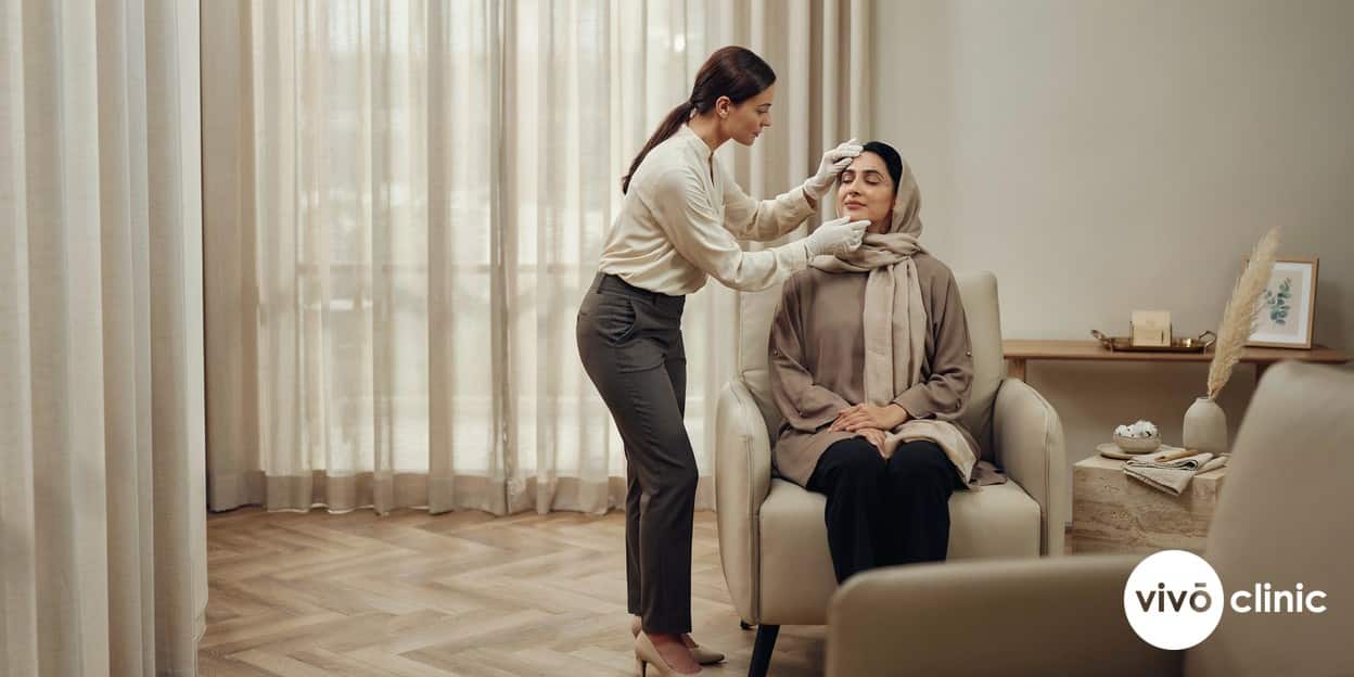 Practitioner in modest attire reviewing the healed upper eyelids of a Middle Eastern woman at a follow-up appointment at VIVO Clinic Dubai, gloved hand gently assessing the skin, no device, machine or handpiece anywhere in frame