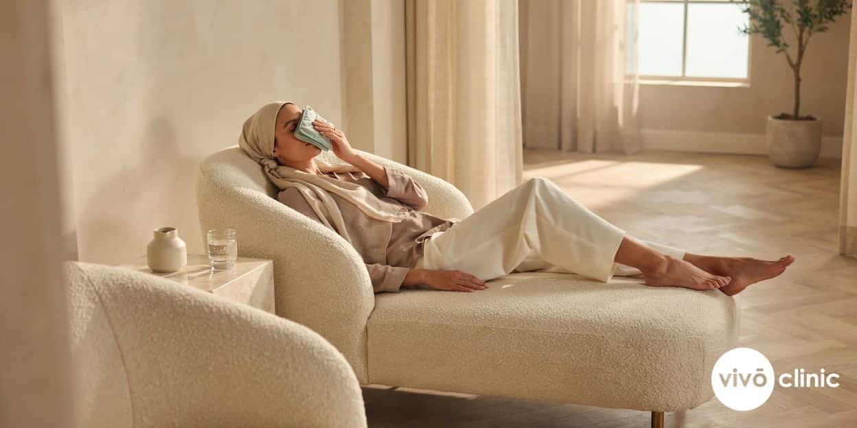 Middle Eastern woman resting calmly with a cool compress over her eyes during plasma eye lift recovery at VIVO Clinic Dubai