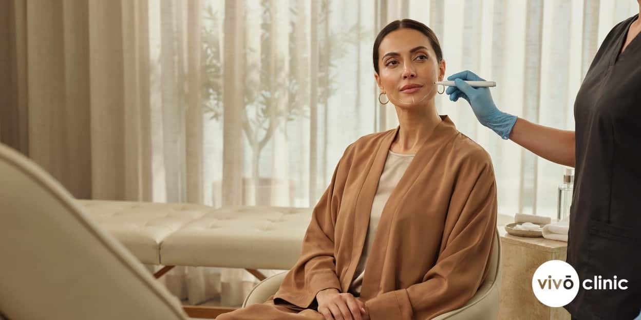 Middle Eastern woman with white cosmetic marking lines along her jawline and jowls during an RF facelift consultation at VIVO Clinic Dubai