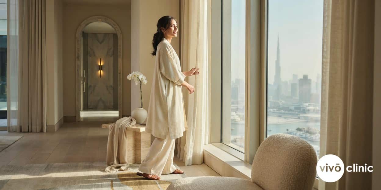 Middle Eastern woman in her forties with healthy, firm skin smiling in natural daylight in a premium Dubai home setting, illustrating the preventive philosophy of an anti-ageing treatment timeline
