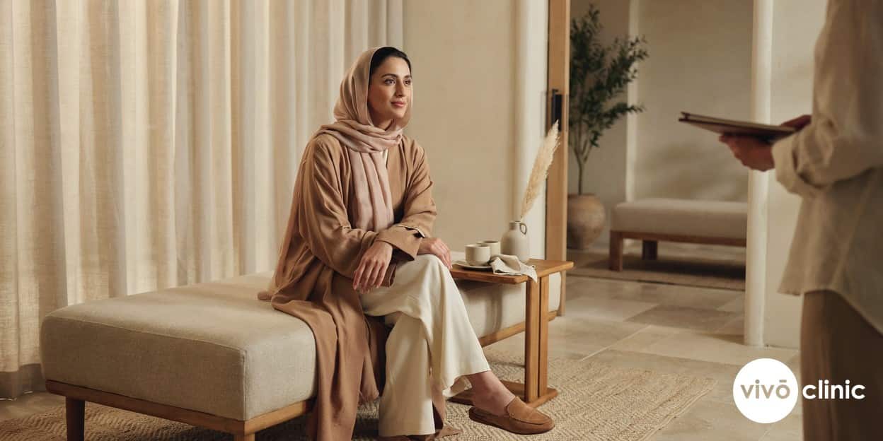 Middle Eastern woman in modest clothing in a calm, private consultation room discussing women’s wellness options at VIVO Clinic Dubai