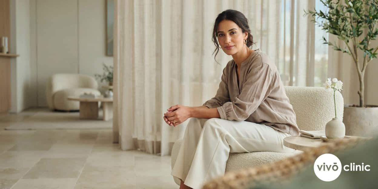 Middle Eastern woman in modest dress looking confident and reassured after a transparent cost consultation in a bright, premium clinic setting in Dubai