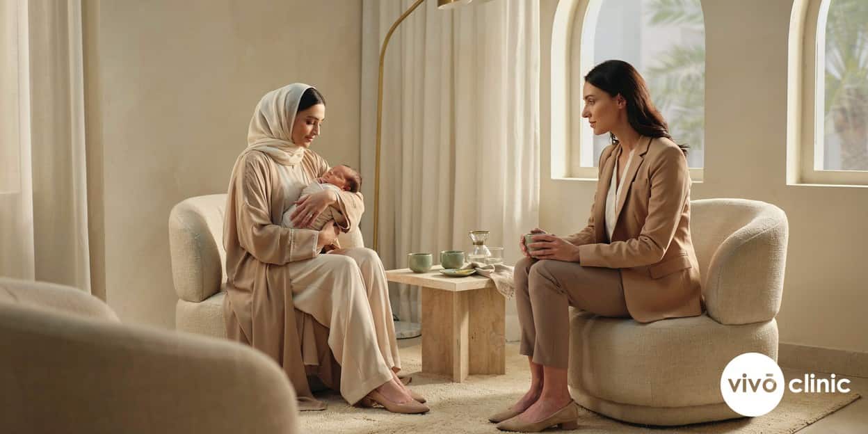 Middle Eastern new mother in modest dress holding her baby during a relaxed post-pregnancy body consultation at VIVO Clinic Dubai
